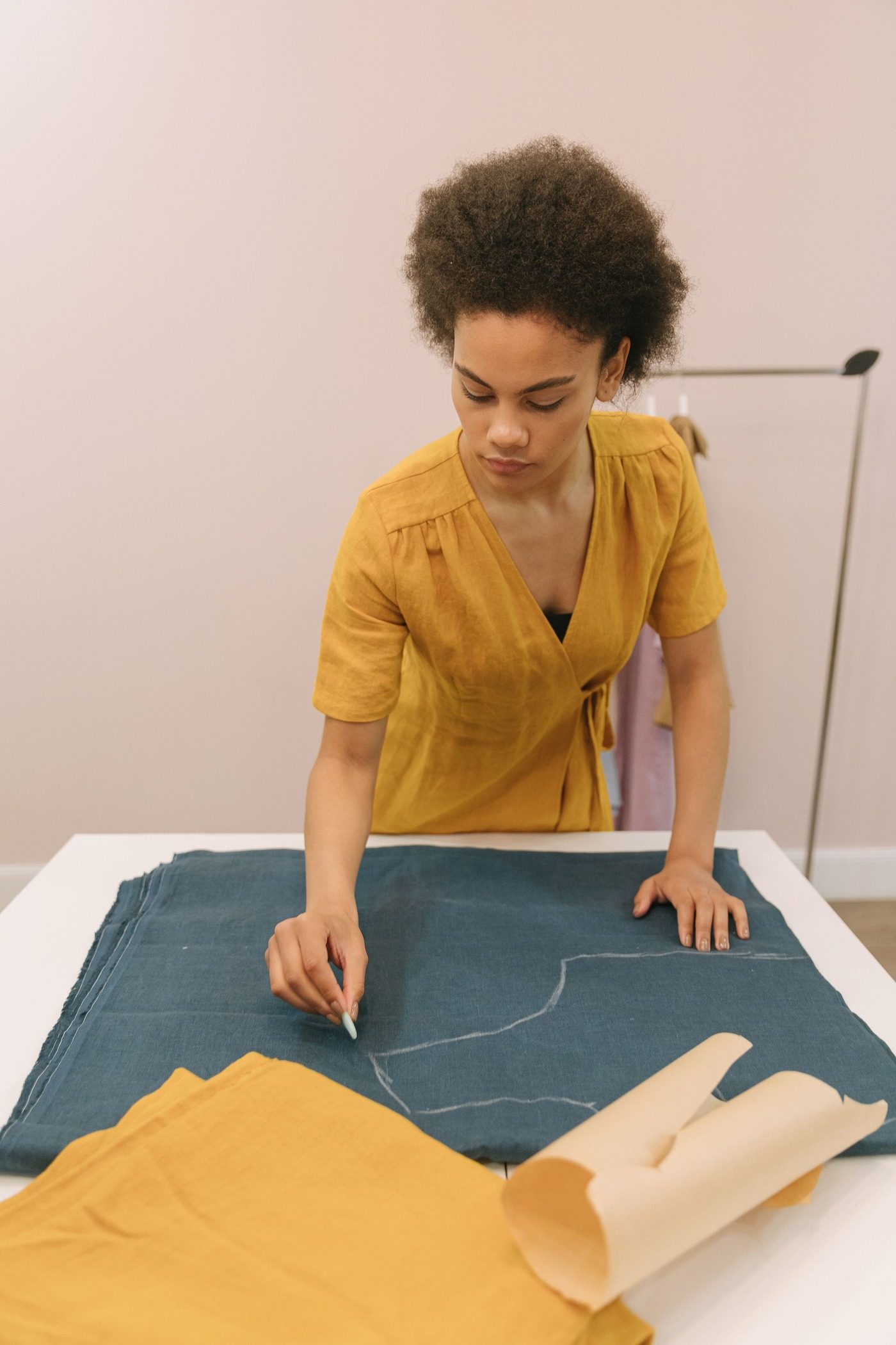A woman marking a pattern onto fabric for a custom apparel order
