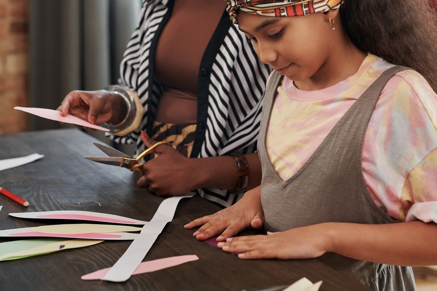 Cutting colored paper shapes by hand at a craft table